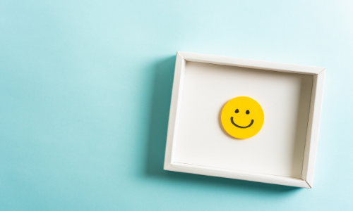 Picture frame with a smiley face inside on a blue wall